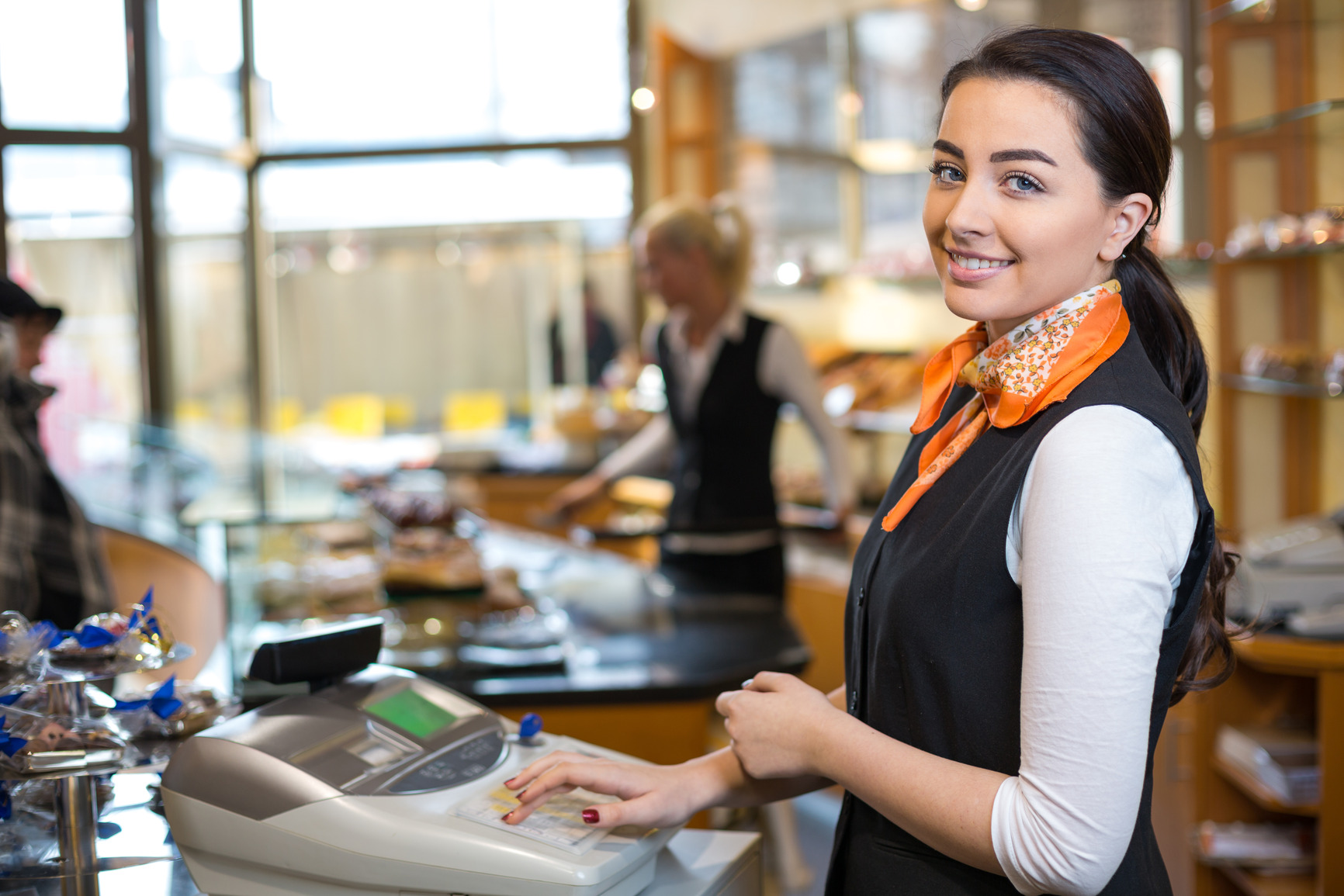 Shopkeeper and saleswoman at cash register or checkout counter